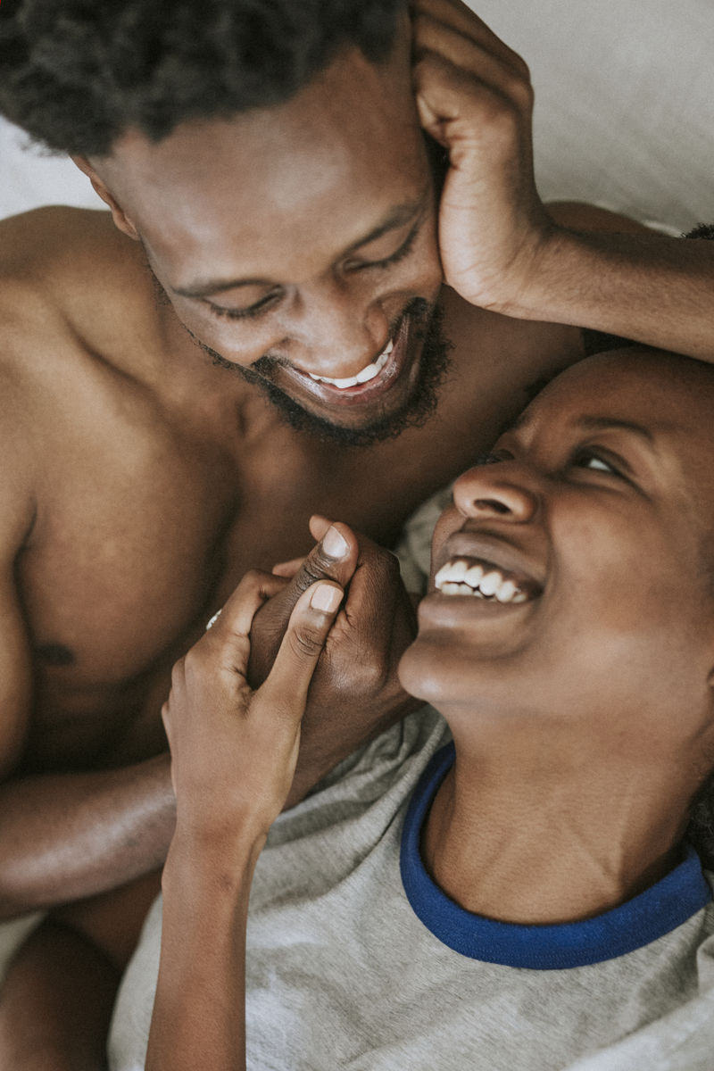 可爱快乐的黑人情侣在床上玩耍