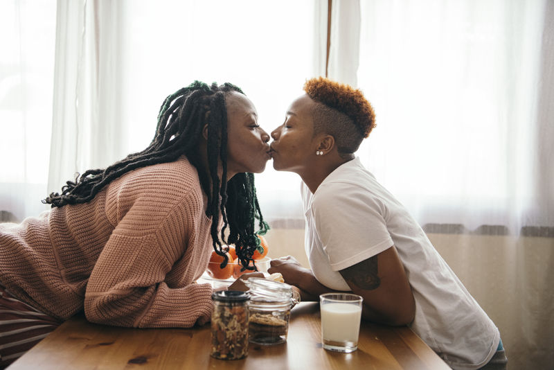 快乐的女同性恋情侣在厨房接吻