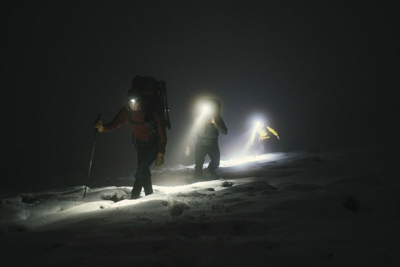 苏格兰格伦科的登山者在寒冷的夜晚徒步旅行