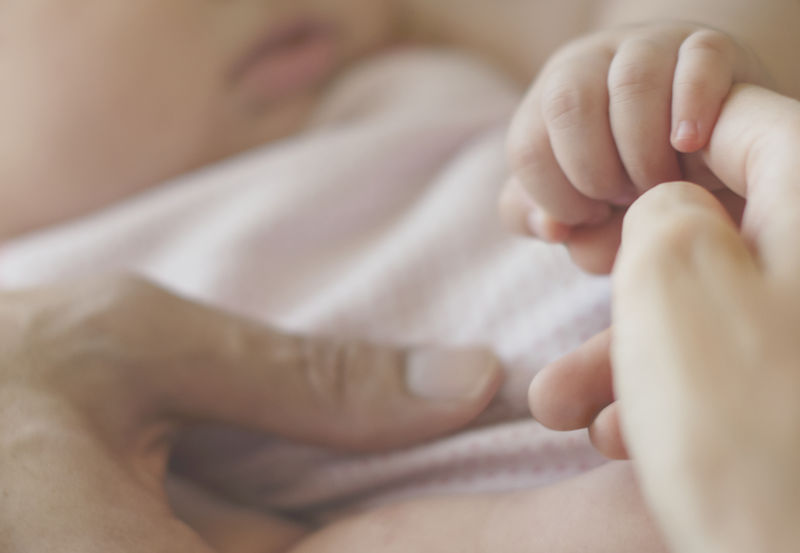 婴儿牵着妈妈的手的特写镜头