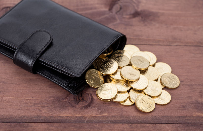 黑色皮革钱包背景为金色硬币