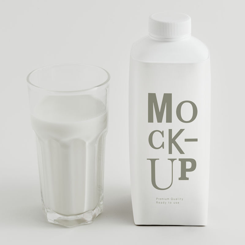 新鲜牛奶在一个杯子里和一个瓶子模型