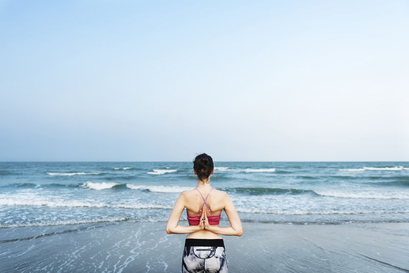 一个女人正在海滩上做瑜伽
