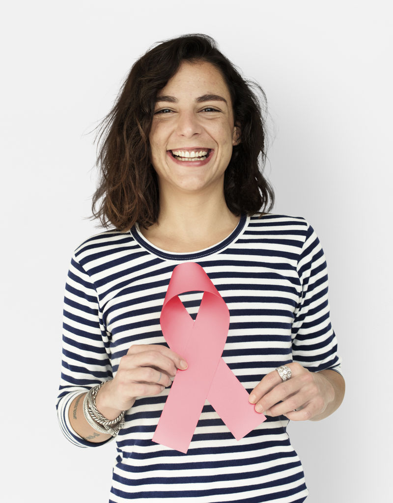 随意的年轻女子拿着粉红色丝带代表着对乳腺癌的认识