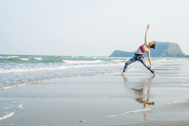 一个女人正在海滩上做瑜伽