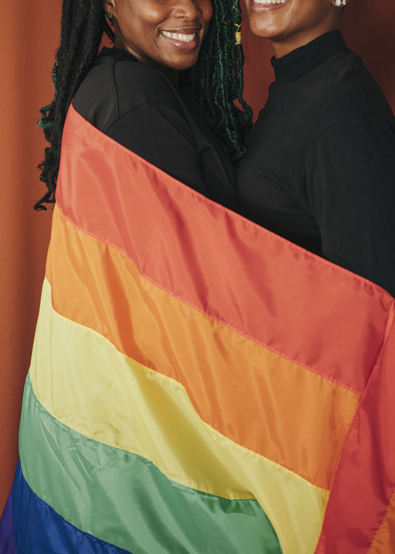 一对快乐的女同性恋夫妇手举彩旗