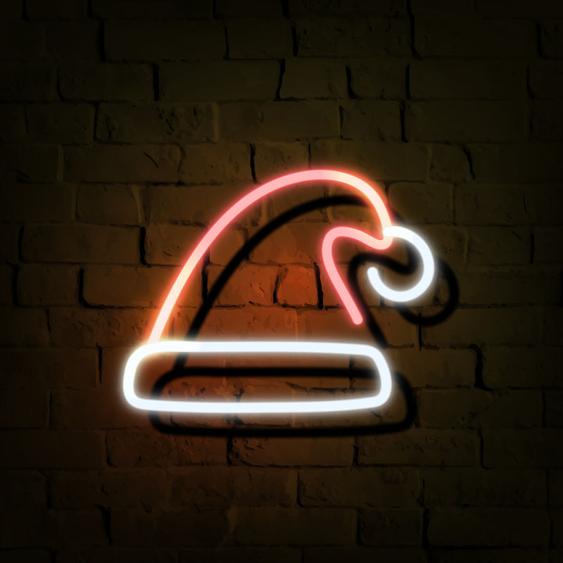 黑色砖墙上的圣诞帽霓虹灯标志