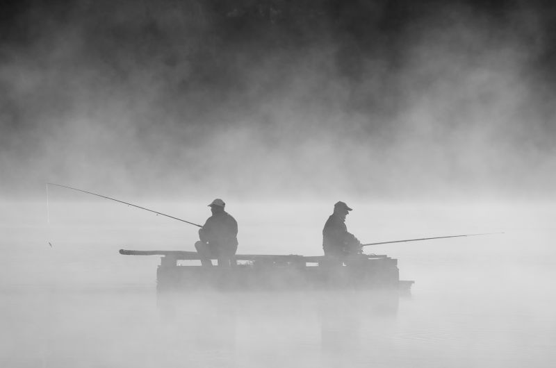在雾中钓鱼的两个人