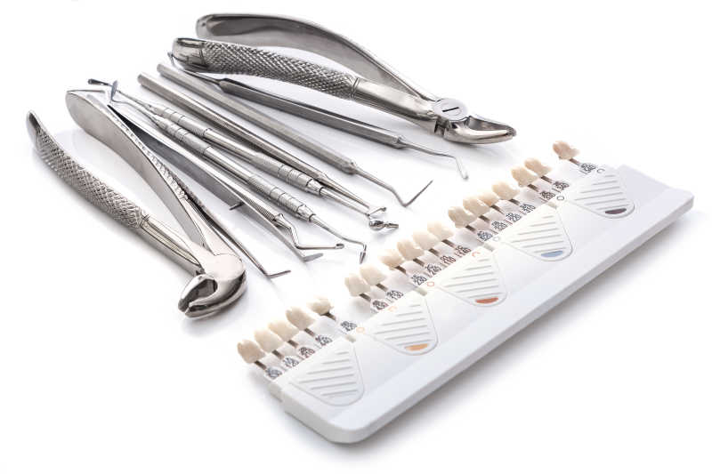 白色桌上的牙科工具与牙齿模型展示板