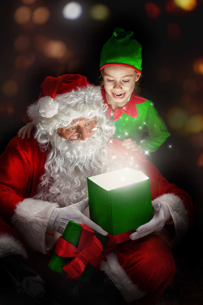 圣诞老人和小女孩一起打开魔术盒子