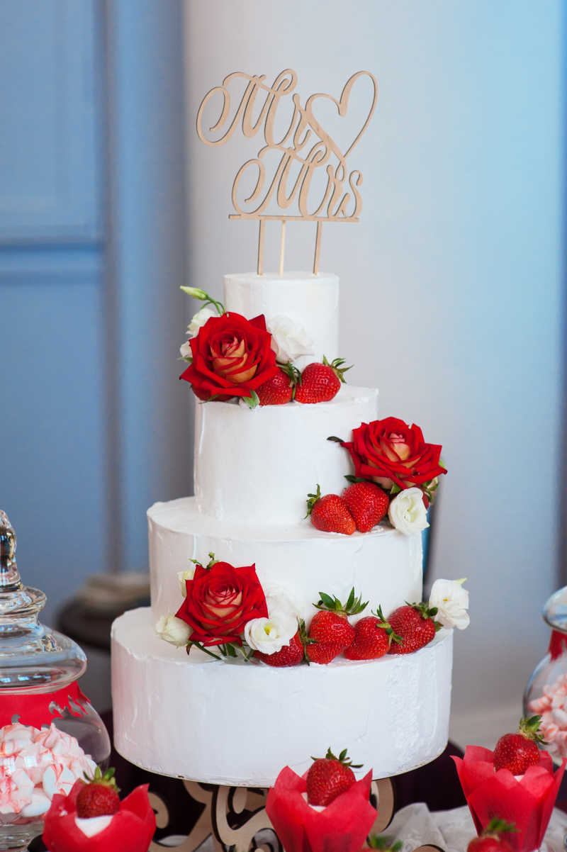 红玫瑰装饰的白色婚礼蛋糕