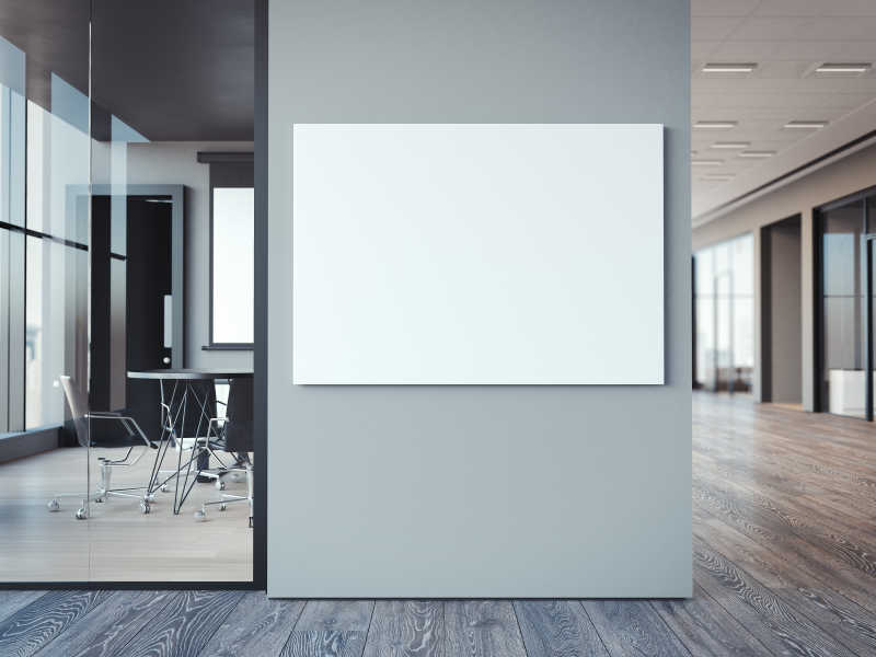 现代办公室灰色墙壁上的空白白色框架