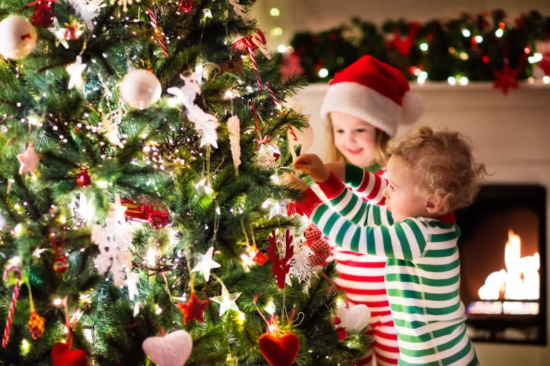 儿童专心的给圣诞树装饰