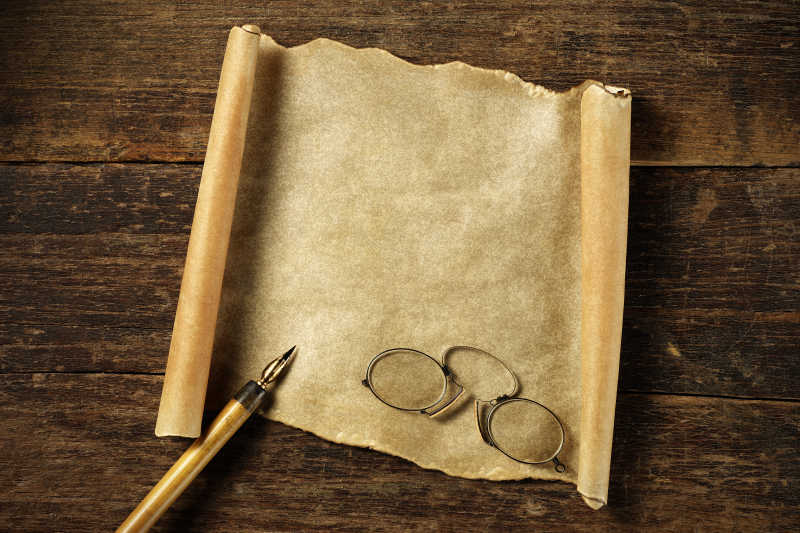 旧空白羊皮纸上的眼镜和笔