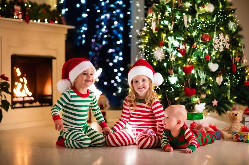 圣诞树下穿睡衣的孩子一起快乐的笑