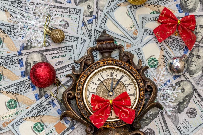 铺满纸币的桌上的古老的钟表和圣诞节装饰品