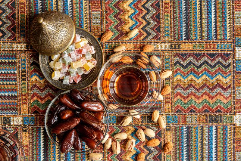 传统阿拉伯地毯上的糖果和茶与坚果